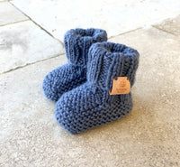 hand knitted top knot hat and matching booties, denim colour, sizes 0-12 months. softest australian merino wool, stay on booties